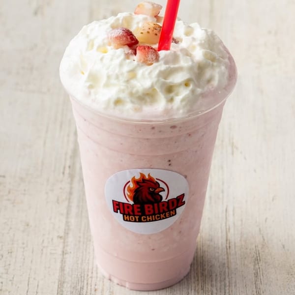 Strawberry milkshake with whipped cream, strawberry pieces, and a red straw, featuring the Fire Birdz logo.