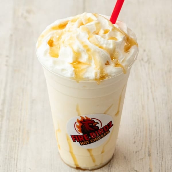 Firebirdz Hot Chicken milkshake with whipped cream, caramel drizzle, and a red straw.