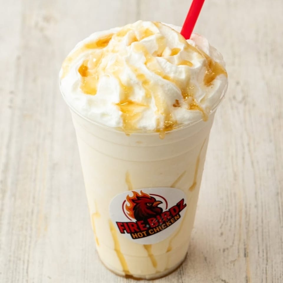 Firebirdz Hot Chicken milkshake with whipped cream, caramel drizzle, and a red straw.