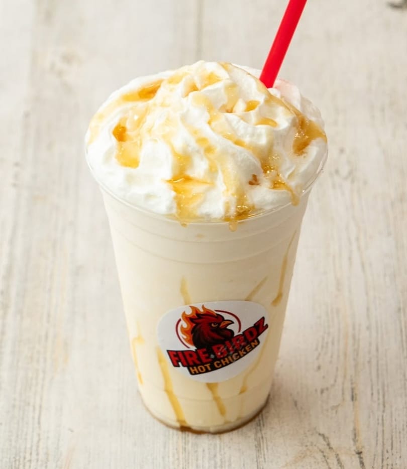 Firebirdz Hot Chicken milkshake with whipped cream, caramel drizzle, and a red straw.